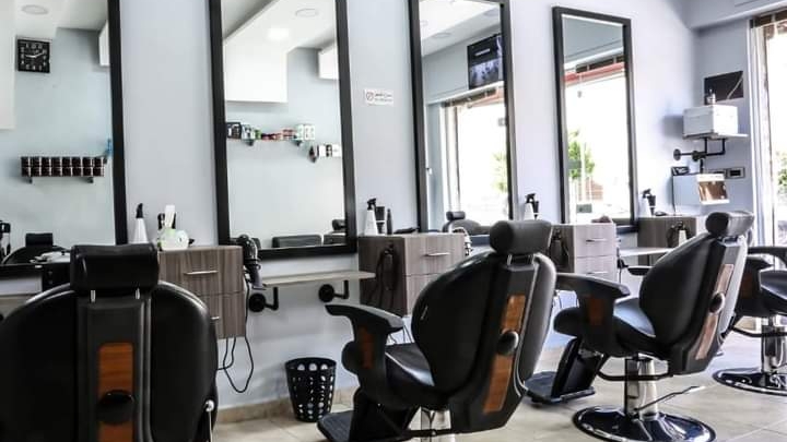 Row of black barber chairs and mirrors inside Makkawi's Barber Shop