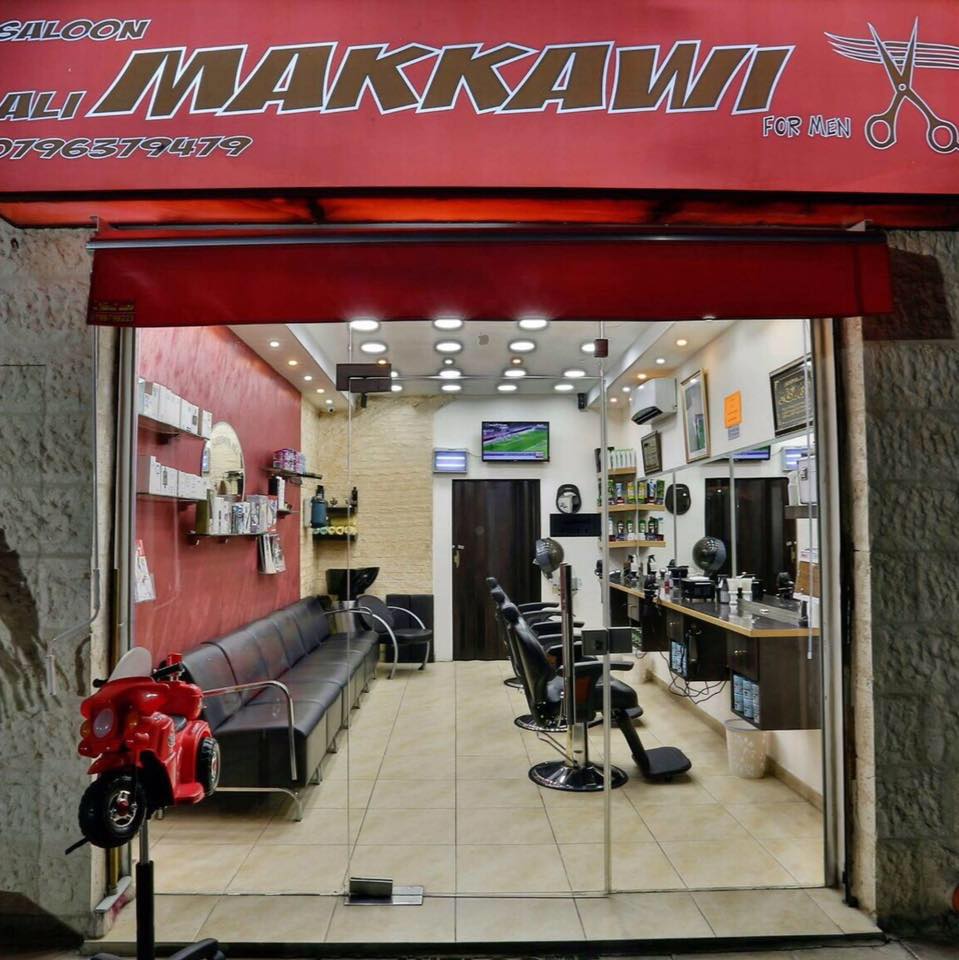 Makkawi Barber Shop entrance lit up in the evening