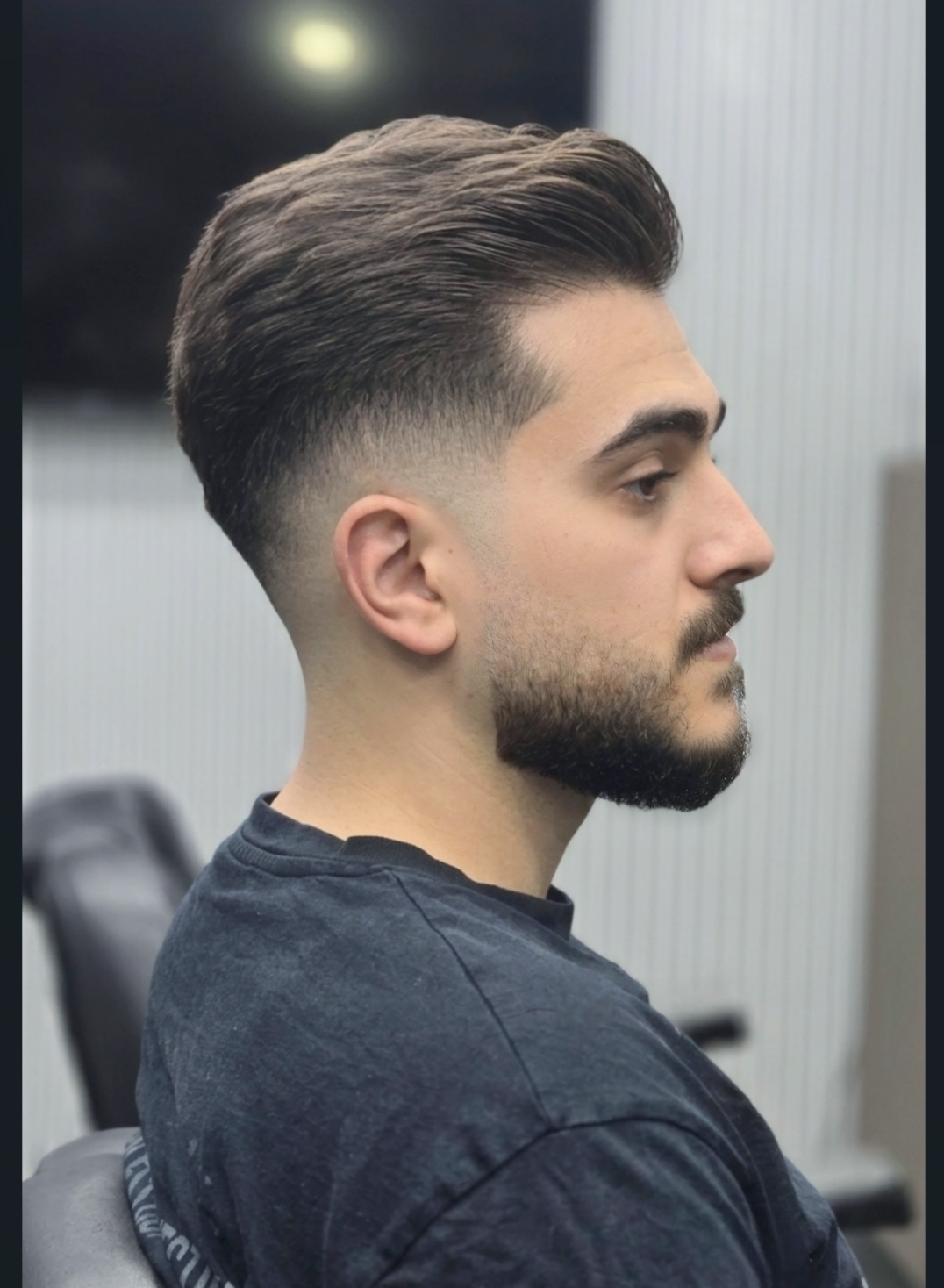 Finished slicked-back fade with a full groomed beard at Makkawi's