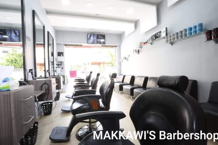 Wide view of the styling floor with a product wall at Makkawi's Barber Shop