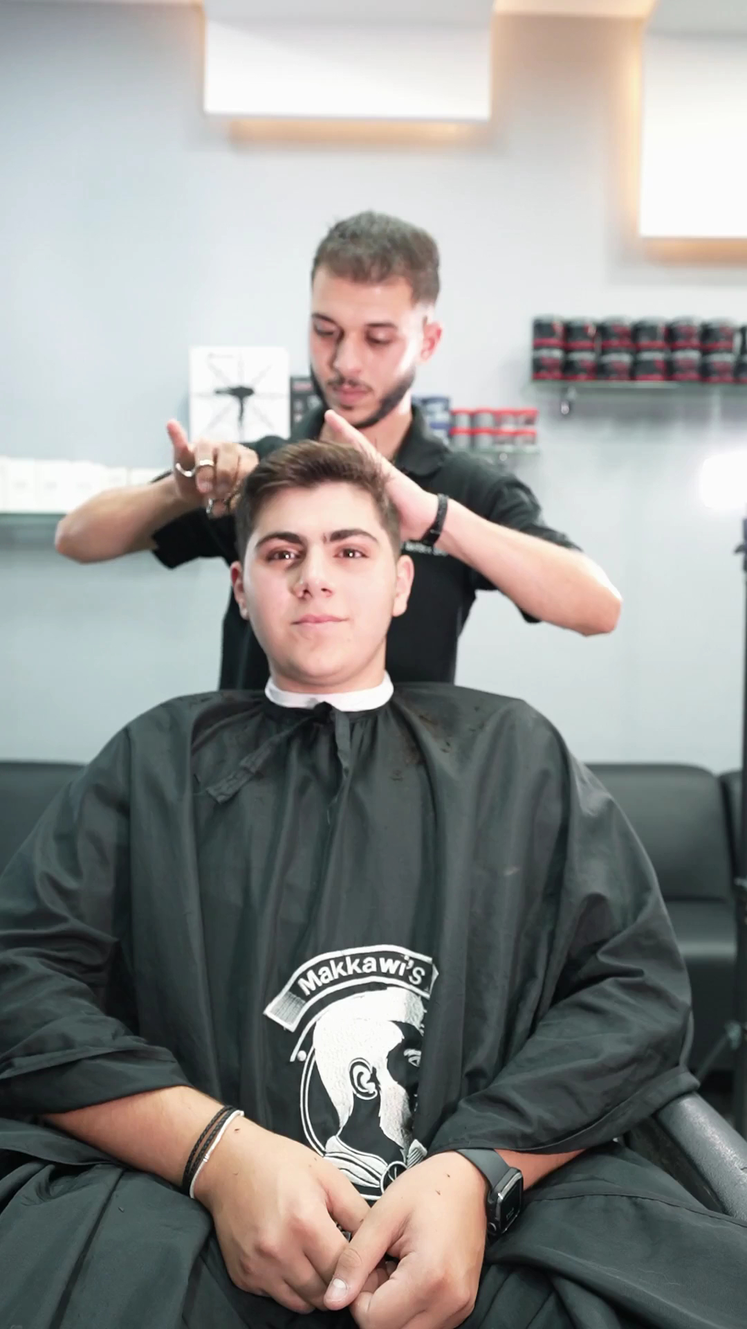 Barber at work on a client in a branded Makkawi's cape